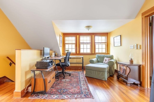 home office with hardwood / wood-style flooring, vaulted ceiling, and baseboards