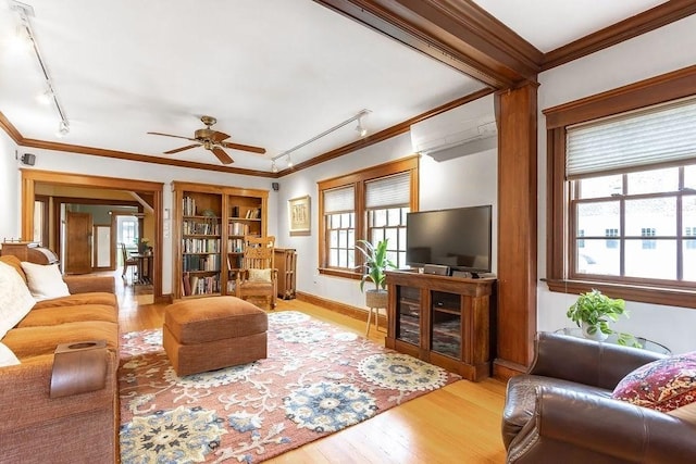 living area featuring rail lighting, an AC wall unit, wood finished floors, and ornamental molding