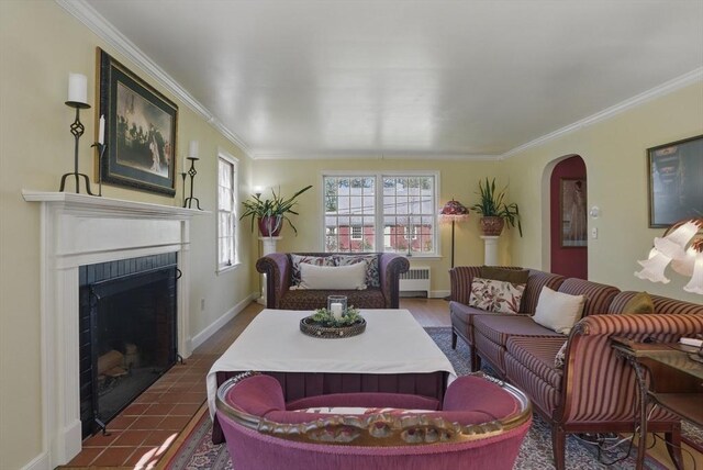 128 Lovell Rd, Holden, MA 01520 - living area featuring radiator heating unit, crown molding, arched walkways, a fireplace with flush hearth, and dark wood-type flooring