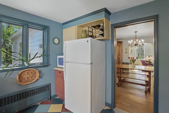 128 Lovell Rd, Holden, MA 01520 - kitchen featuring white appliances, radiator heating unit, and a chandelier