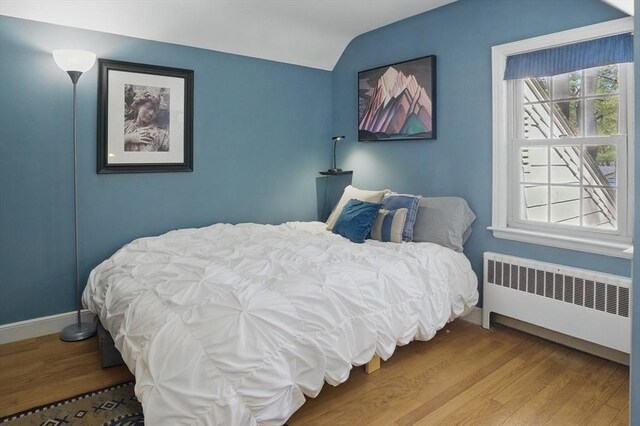 128 Lovell Rd, Holden, MA 01520 - bedroom with radiator heating unit, wood finished floors, vaulted ceiling, and baseboards
