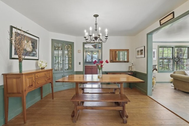 128 Lovell Rd, Holden, MA 01520 - dining space with a chandelier, light wood-style flooring, and a wainscoted wall