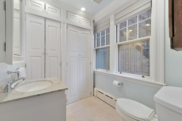 bathroom with baseboard heating, toilet, tile patterned floors, and vanity
