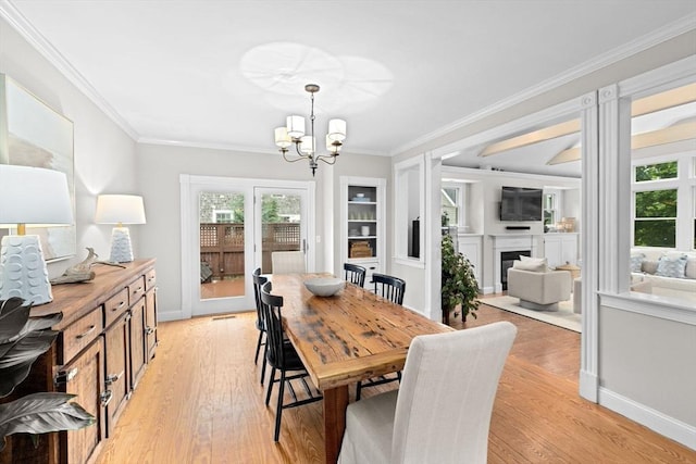 12 Short St, Cohasset, MA 02025 - dining room with a chandelier, crown molding, a fireplace, healthy amount of natural light, and light wood-style floors