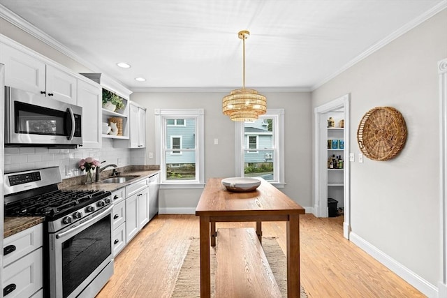 12 Short St, Cohasset, MA 02025 - kitchen with appliances with stainless steel finishes, crown molding, light wood-type flooring, open shelves, and a chandelier