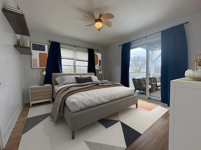 bedroom with access to exterior, ceiling fan, dark hardwood / wood-style flooring, and multiple windows