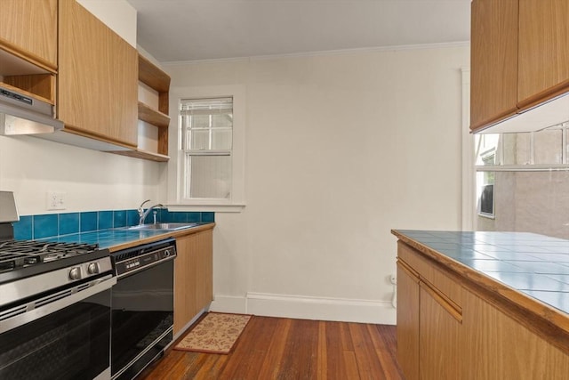 kitchen featuring dishwasher, stainless steel gas range, open shelves, a sink, and tile counters