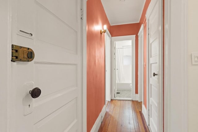 corridor with light wood finished floors and baseboards