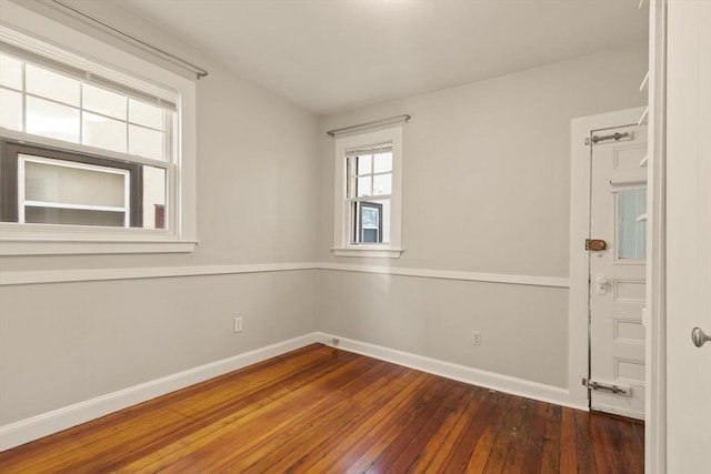 unfurnished room with wood-type flooring and baseboards