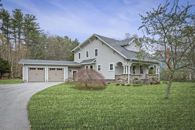 view of front facade with a porch, a garage, a front lawn, and driveway