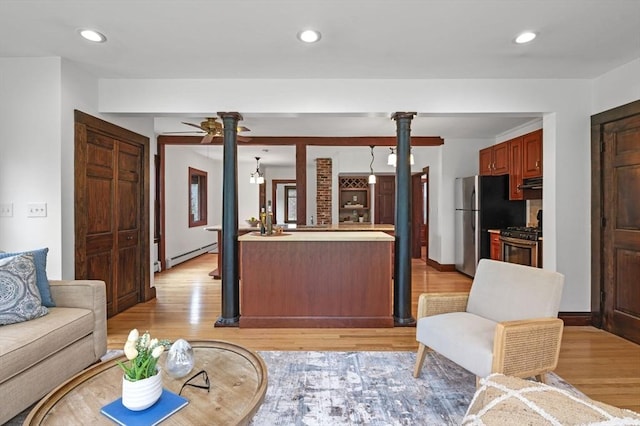 living room with recessed lighting, baseboard heating, a ceiling fan, and light wood finished floors