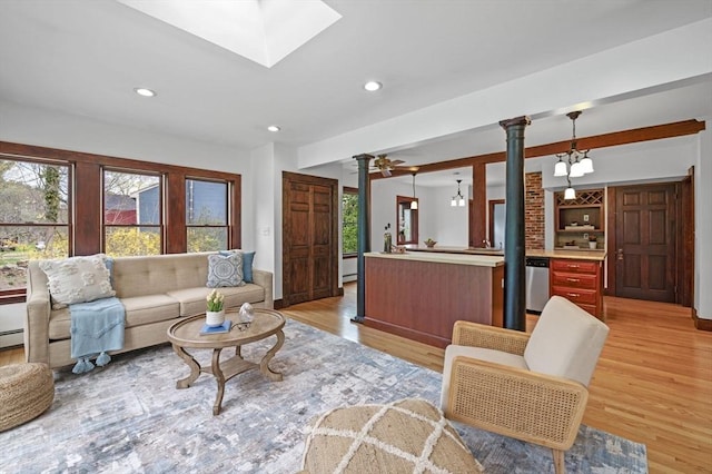 living area featuring light wood-style floors, recessed lighting, and ornate columns