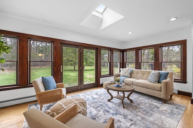 living area with a skylight, a baseboard radiator, recessed lighting, and wood finished floors