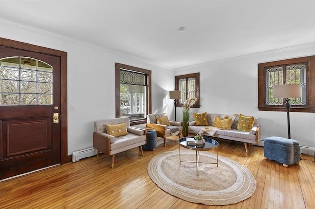living area with plenty of natural light, light wood-style floors, and crown molding
