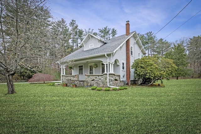 view of front of house with a porch, a chimney, and a front lawn