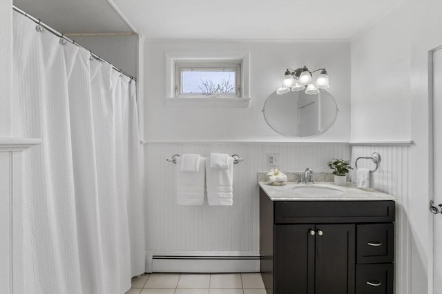 full bathroom featuring vanity, a wainscoted wall, tile patterned flooring, and a baseboard heating unit