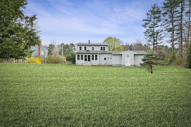 rear view of house with a lawn and entry steps