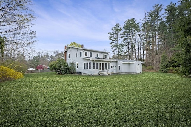 back of house with a yard, a chimney, and entry steps