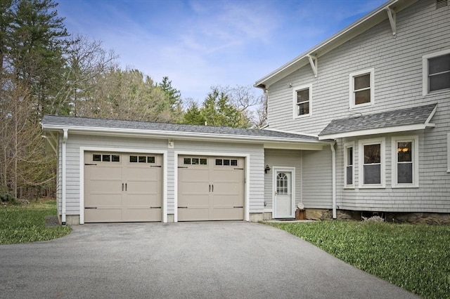 view of front of house featuring a garage, aphalt driveway, and a shingled roof