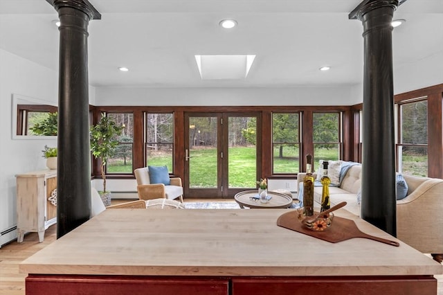 interior space featuring recessed lighting, a skylight, a baseboard heating unit, and light wood-style flooring