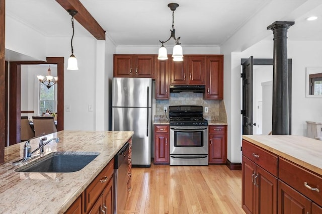kitchen featuring a chandelier, a sink, appliances with stainless steel finishes, exhaust hood, and decorative light fixtures