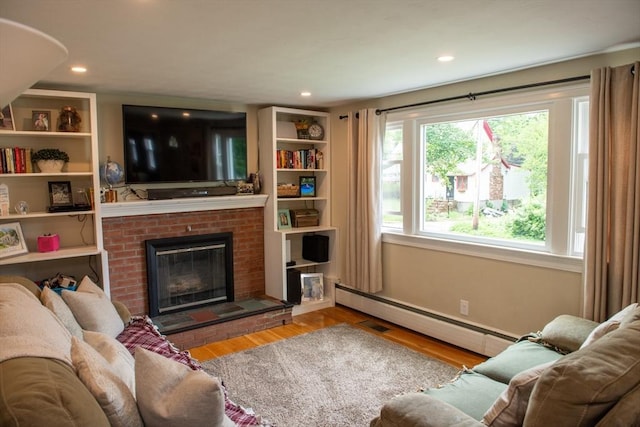 15 Lambert Ave, Stoughton, MA 02072 - living area with a baseboard radiator, wood finished floors, a brick fireplace, and recessed lighting