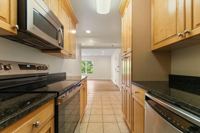 188 Newton Unit 6, Boston, MA 02135 - kitchen featuring appliances with stainless steel finishes, light tile patterned flooring, recessed lighting, dark stone counters, and baseboards
