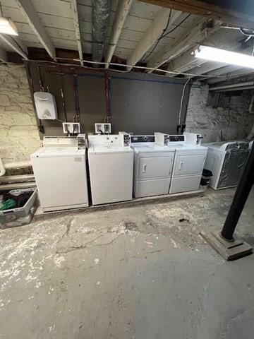 unfinished below grade area with washing machine and clothes dryer