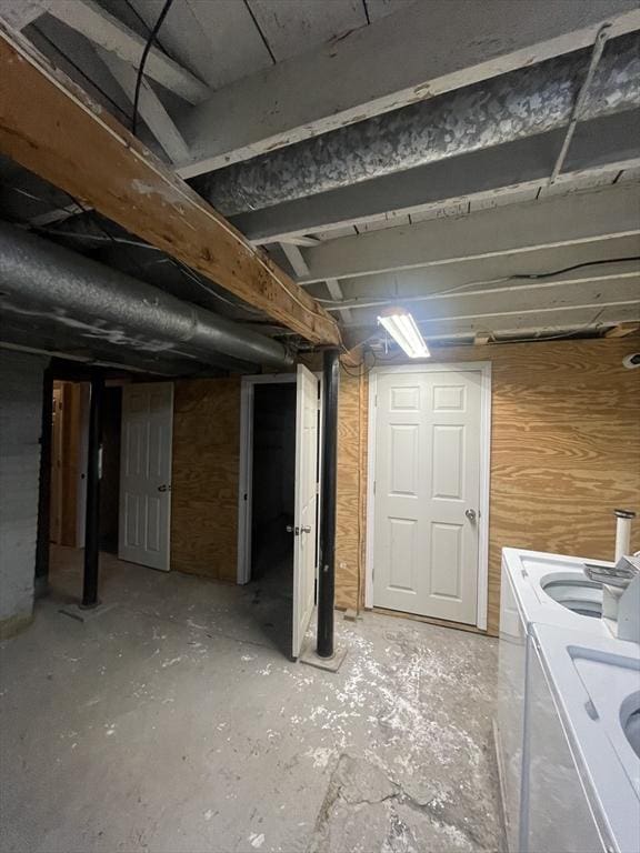 unfinished below grade area featuring independent washer and dryer and wood walls