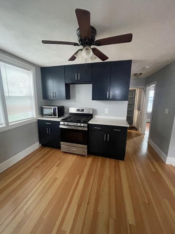 kitchen with stainless steel appliances, light countertops, and dark cabinets