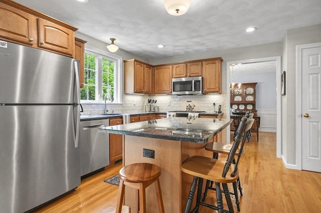 155 Burlington St, Woburn, MA 01801 - kitchen with stainless steel appliances, a sink, a kitchen bar, a center island, and light wood-style floors