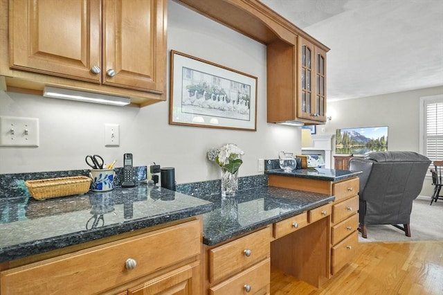 155 Burlington St, Woburn, MA 01801 - kitchen with light wood-style floors, glass insert cabinets, dark stone counters, and brown cabinetry