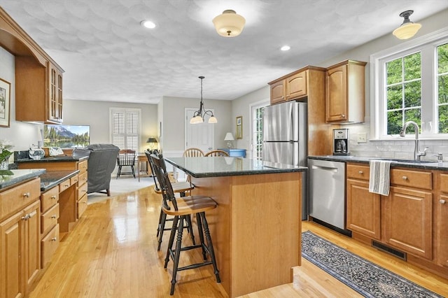 155 Burlington St, Woburn, MA 01801 - kitchen with appliances with stainless steel finishes, a kitchen bar, a kitchen island, plenty of natural light, and recessed lighting