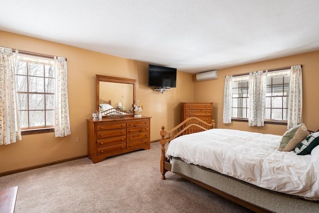 carpeted bedroom with an AC wall unit and baseboards