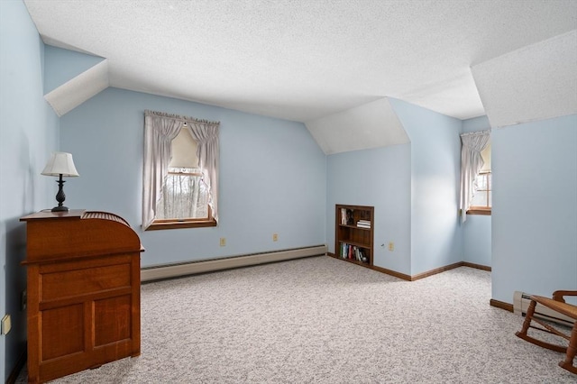 additional living space featuring a textured ceiling, baseboard heating, carpet flooring, and lofted ceiling