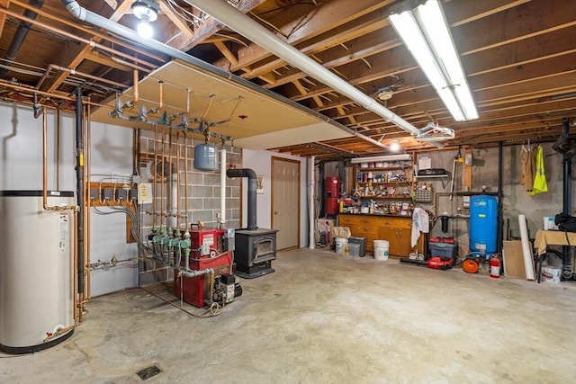 unfinished below grade area with water heater, a heating unit, and a wood stove