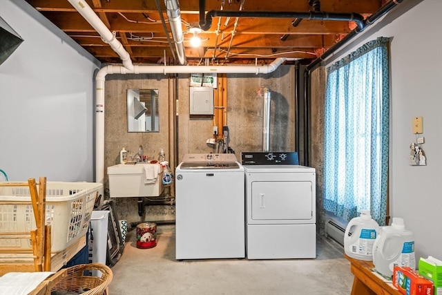 laundry room featuring laundry area, baseboard heating, separate washer and dryer, and a sink