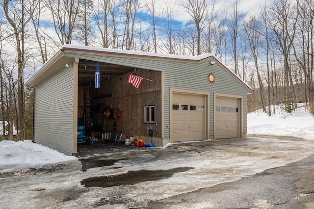 snow covered garage featuring a detached garage