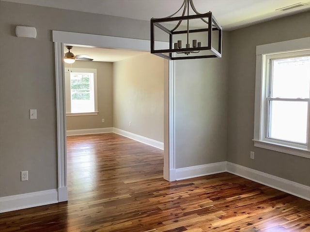 unfurnished dining area with ceiling fan and dark wood-type flooring