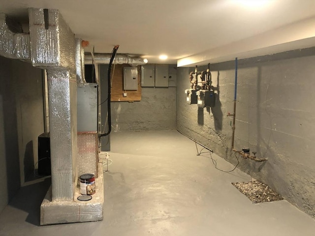 basement featuring electric panel and heating unit