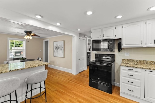 31 Webster St, Randolph, MA 02368 - kitchen featuring black appliances, baseboards, a breakfast bar area, light wood-style flooring, and recessed lighting