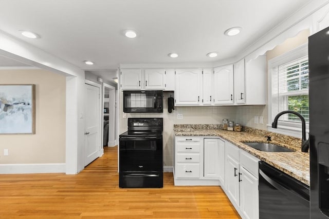 31 Webster St, Randolph, MA 02368 - kitchen with black appliances, a sink, white cabinets, light stone counters, and light wood finished floors