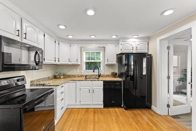31 Webster St, Randolph, MA 02368 - kitchen featuring black appliances, light stone countertops, white cabinetry, and a sink