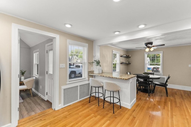 31 Webster St, Randolph, MA 02368 - kitchen featuring light wood-style floors, a kitchen bar, plenty of natural light, baseboards, and ornamental molding