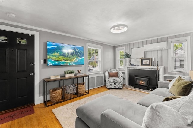 31 Webster St, Randolph, MA 02368 - living room featuring a wall mounted air conditioner, ornamental molding, light wood-type flooring, and a lit fireplace