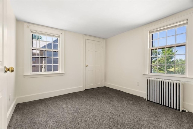 6 River St, Salem, MA 01970 - spare room featuring radiator, dark carpet, and healthy amount of natural light