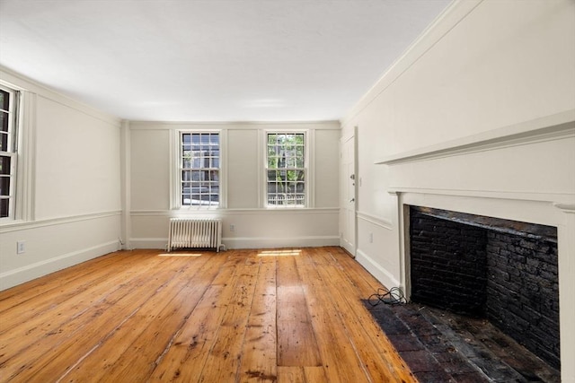 6 River St, Salem, MA 01970 - unfurnished living room with radiator heating unit, wood-type flooring, a fireplace with flush hearth, and ornamental molding