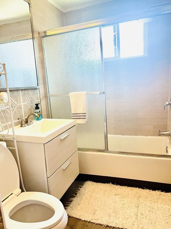 173 Brookway Rd, Boston, MA 02131 - full bath with toilet, enclosed tub / shower combo, vanity, wood finished floors, and crown molding