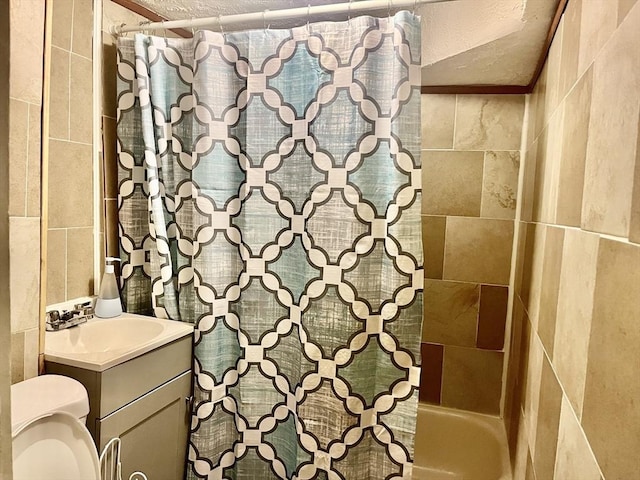 173 Brookway Rd, Boston, MA 02131 - bathroom with tile walls, toilet, vanity, shower / bathtub combination with curtain, and a textured ceiling