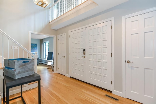 28 Smithshire Ests, Andover, MA 01810 - entrance foyer with light wood-style floors, stairway, and a high ceiling